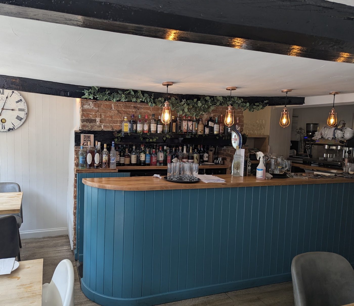 The teal panelled bar under copper pendant lamps